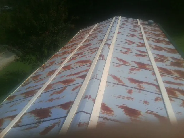 Rusted metal roof panels with new wood purlins before replacement — Storm Damage Roof Repair in Hopedale by Roofing Brothers